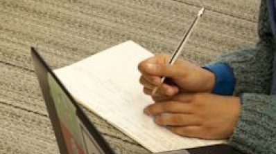 A student writes with a pen.
