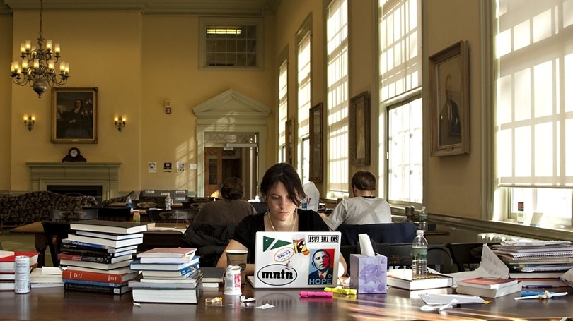 A student works on her laptop in the 1902 Room in Baker Library.